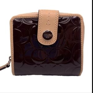 Coach signature embossed black patent leather wallet with a tan leather trim.